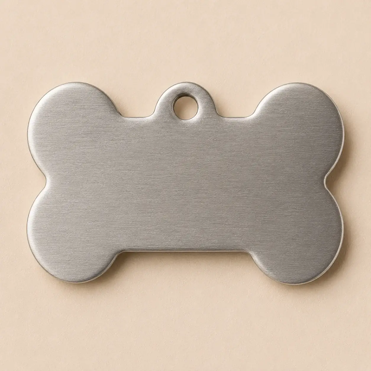 The reverse face of a steel bone tag, blank and ready for the second line of engraving