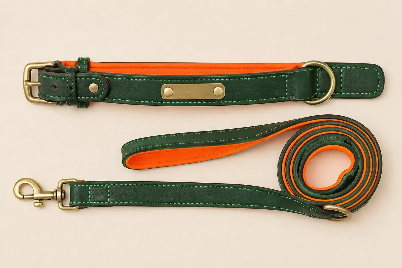 A green leather collar and its matching green leash laid out side by side on a pale surface